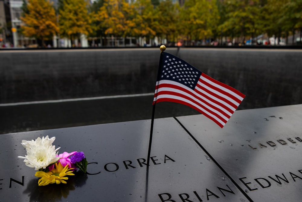 a memorial with a flag and flowers on it