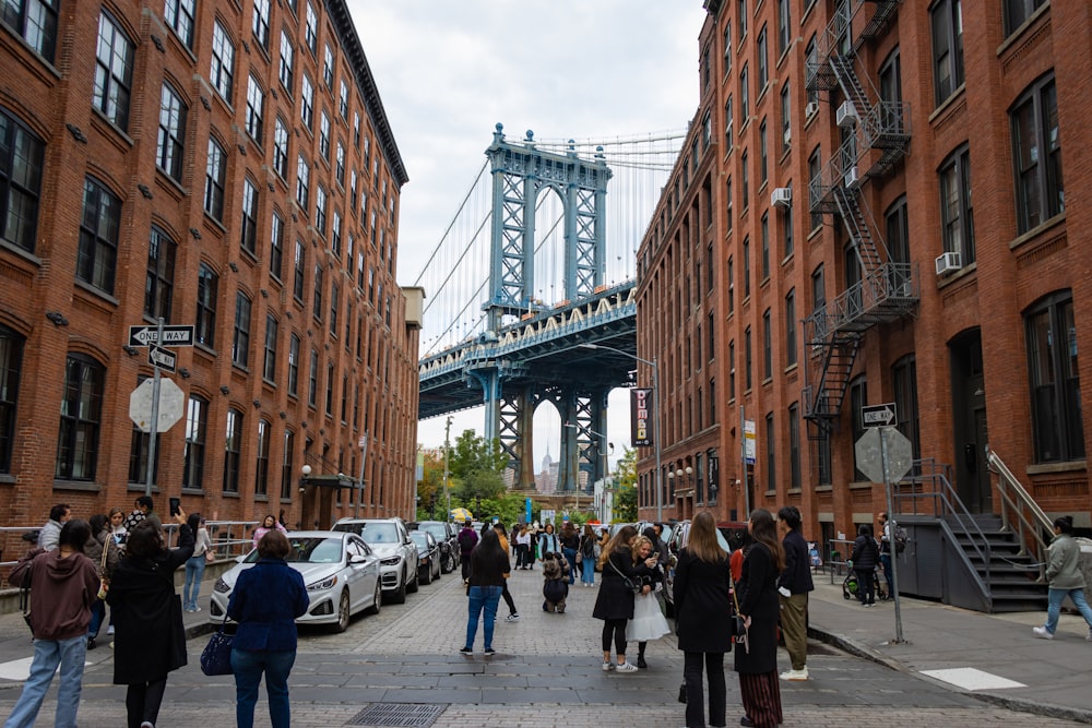 a group of people walking down a street next to tall buildings