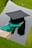 a graduation cap and a green tassel on a piece of wood