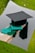 a graduation cap and a green tassel on a piece of wood