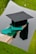 a graduation cap and a green tassel on a piece of wood