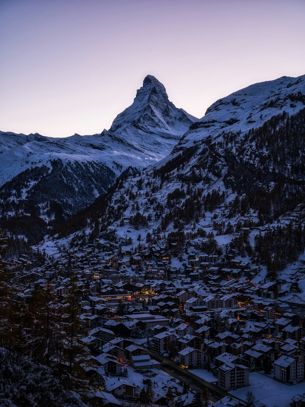 a snow covered mountain with a town below it