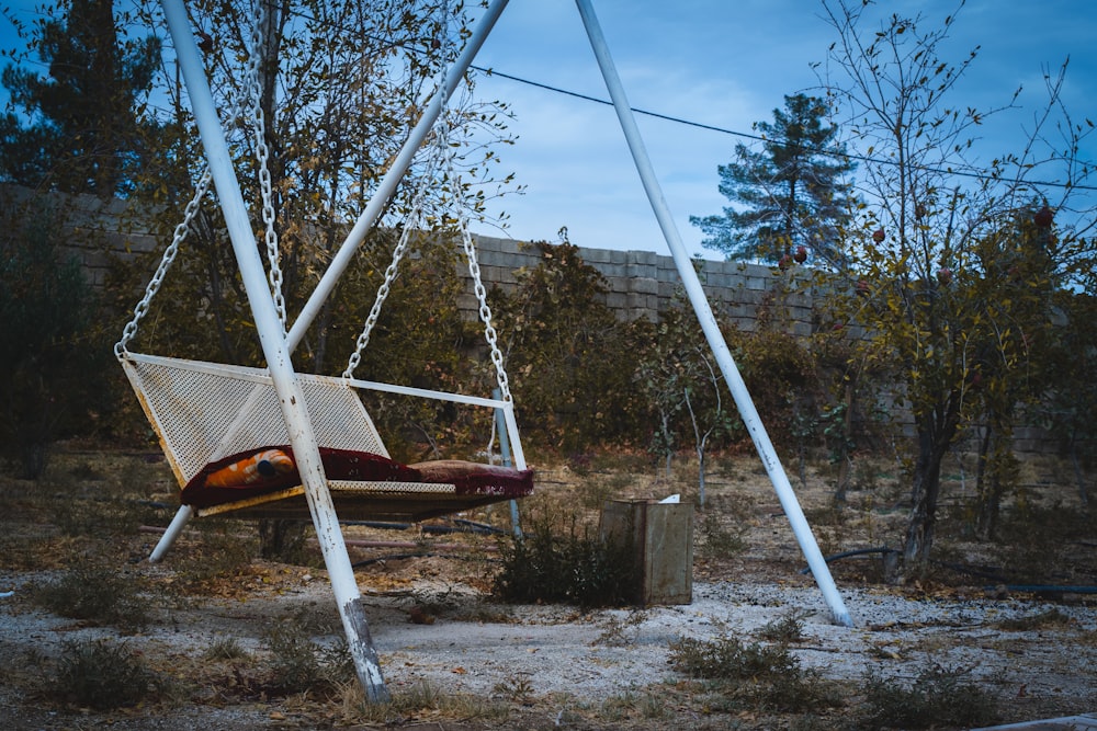 a swing chair sitting in the middle of a field