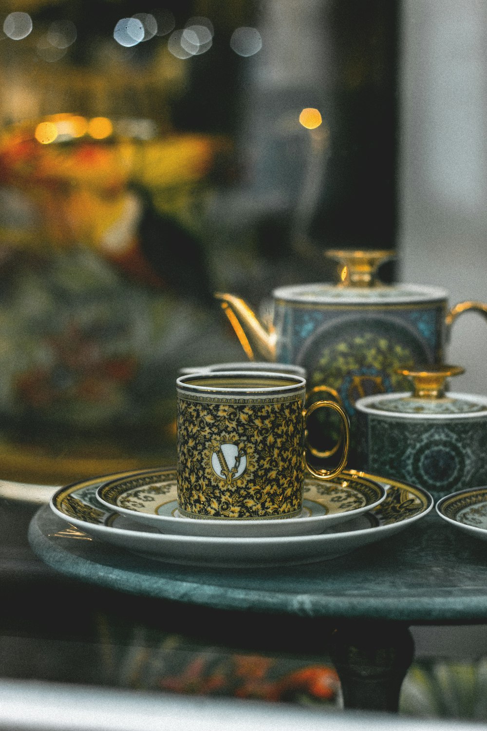 a glass table topped with three cups and saucers