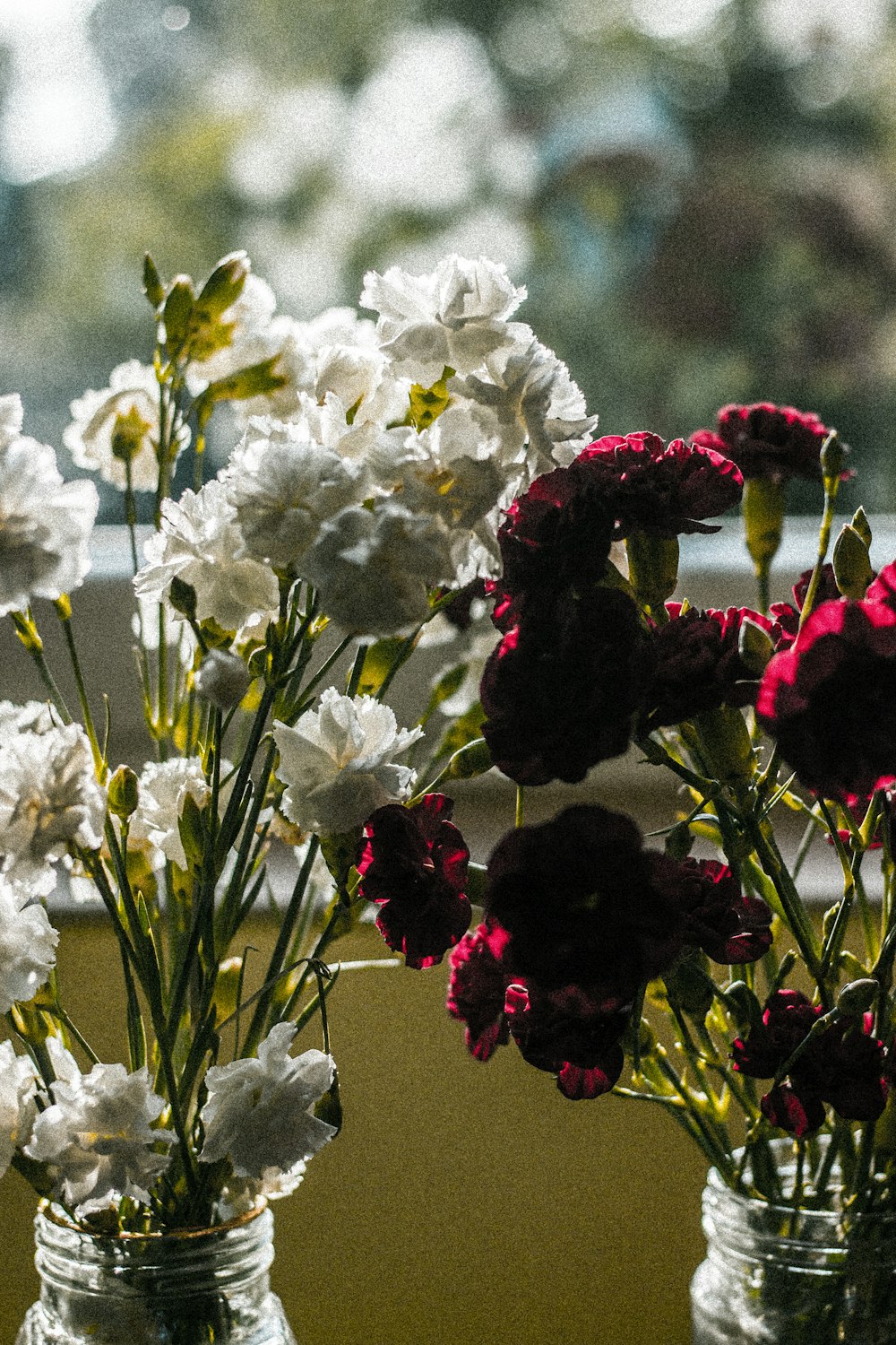 a couple of vases filled with white and red flowers