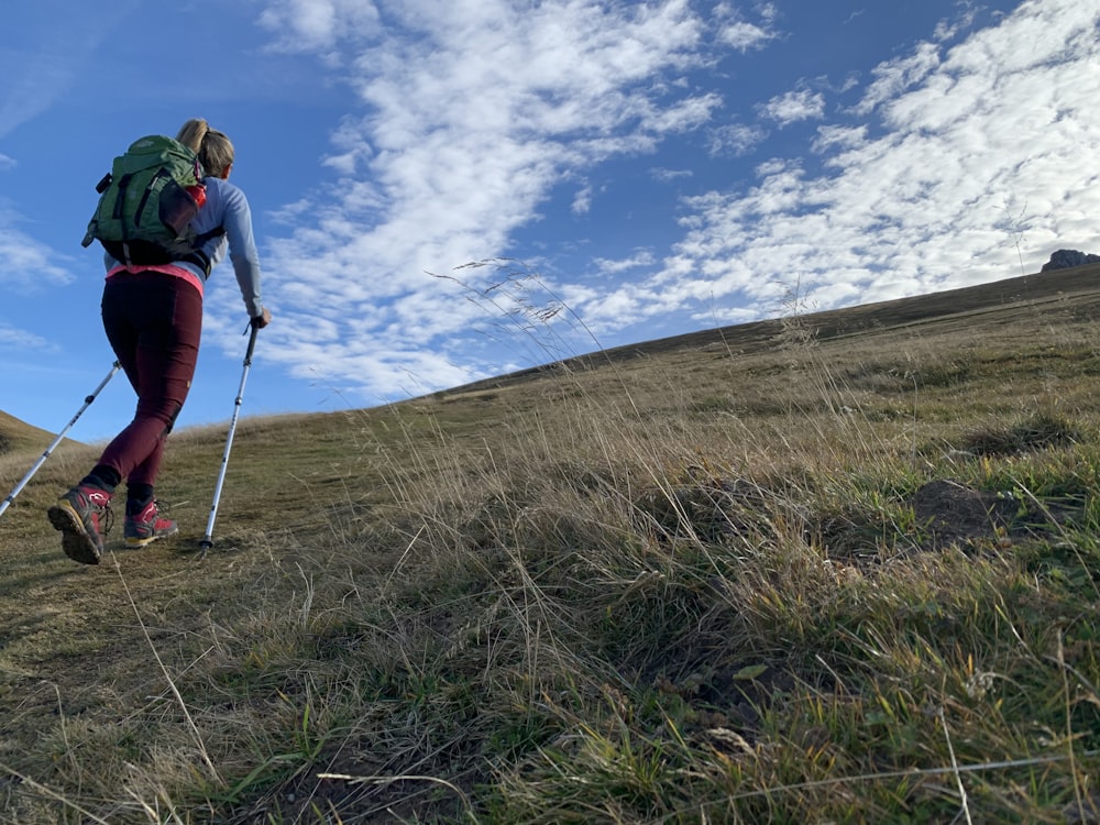 a woman hiking up a hill on a sunny day