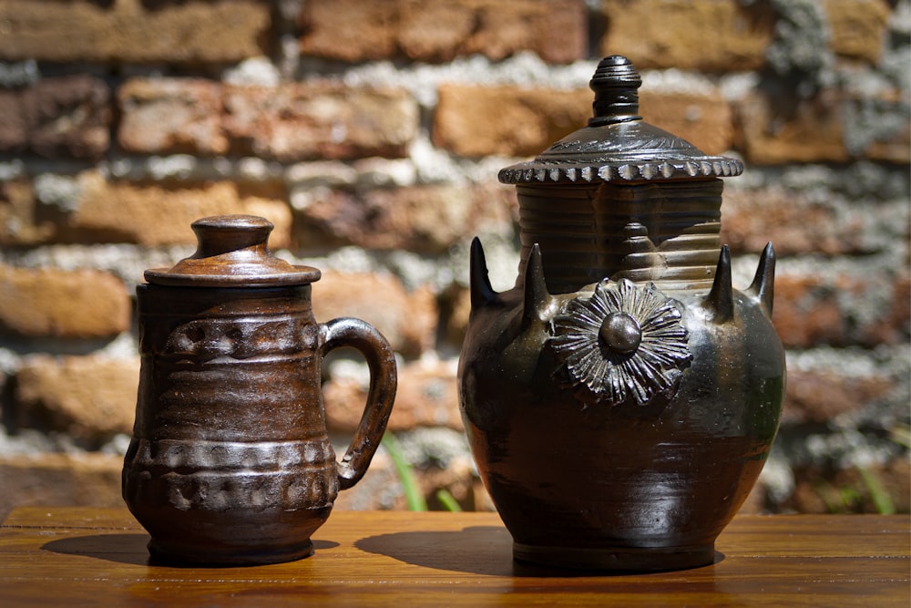 um par de vasos sentados em cima de uma mesa de madeira