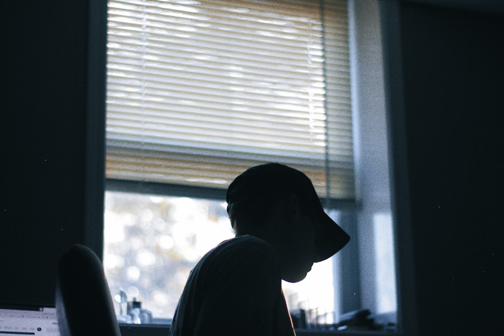 a person sitting at a desk in front of a window