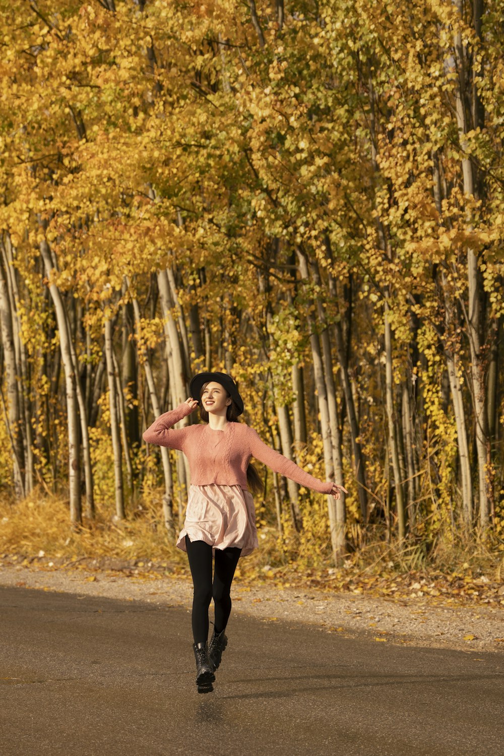 a woman in a pink sweater is running down the road