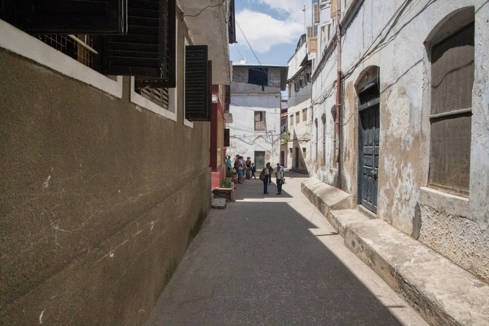 a narrow street with people walking down it