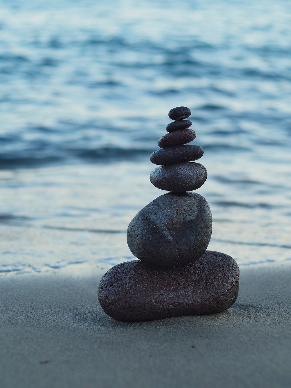 Una pila di rocce sedute sulla cima di una spiaggia sabbiosa