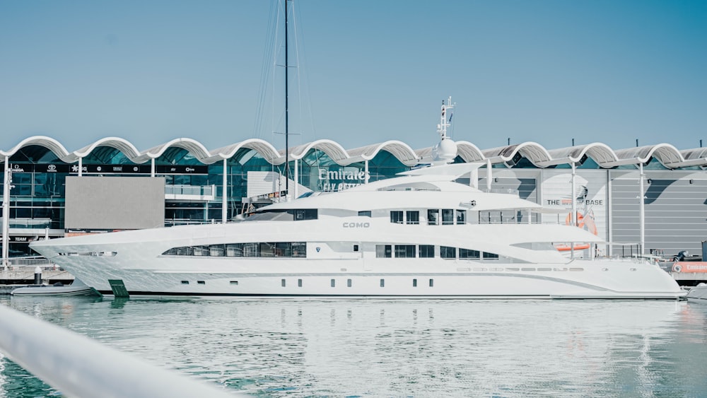 a large white boat in the water near a building