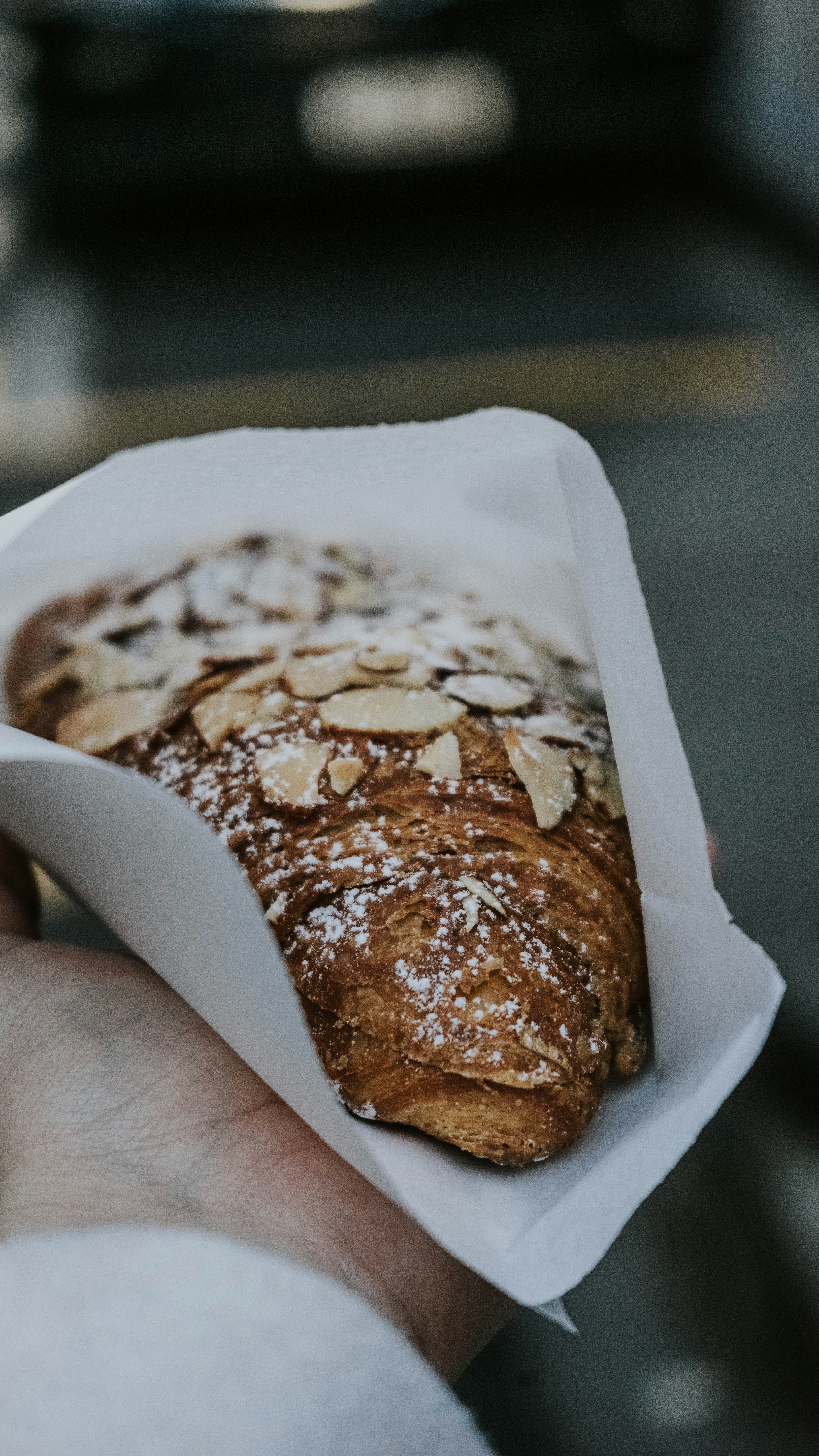 a person holding a pastry in their hand