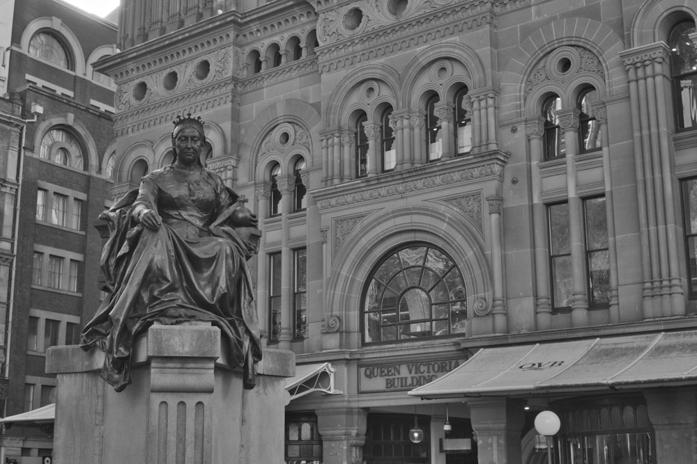 a black and white photo of a statue in front of a building