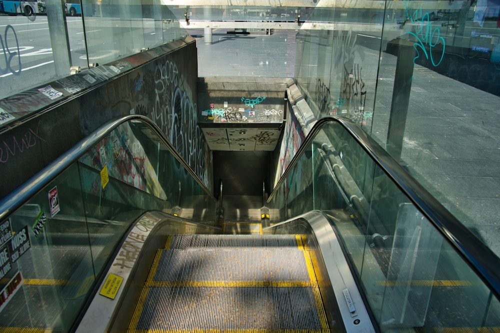 an escalator in a subway station with graffiti on the walls