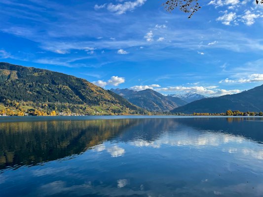 A body of water surrounded by mountains and trees — Zell am See, Austria