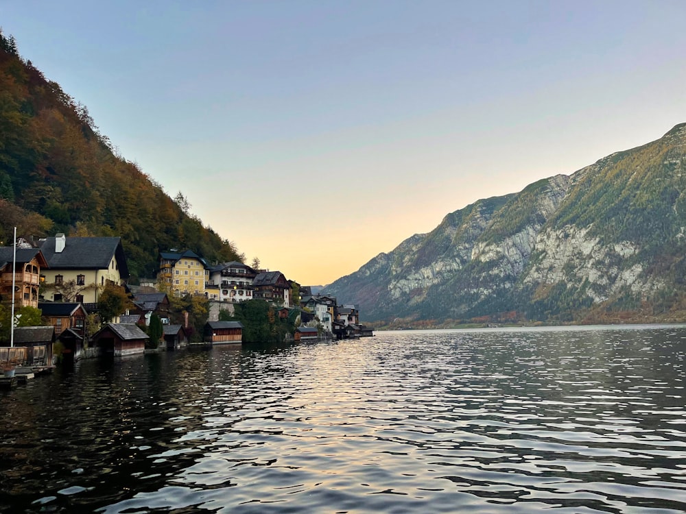 a body of water with houses and mountains in the background