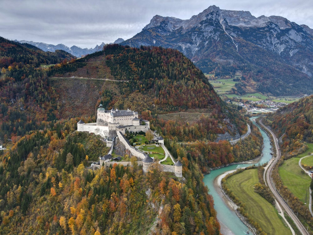 an aerial view of a castle surrounded by mountains