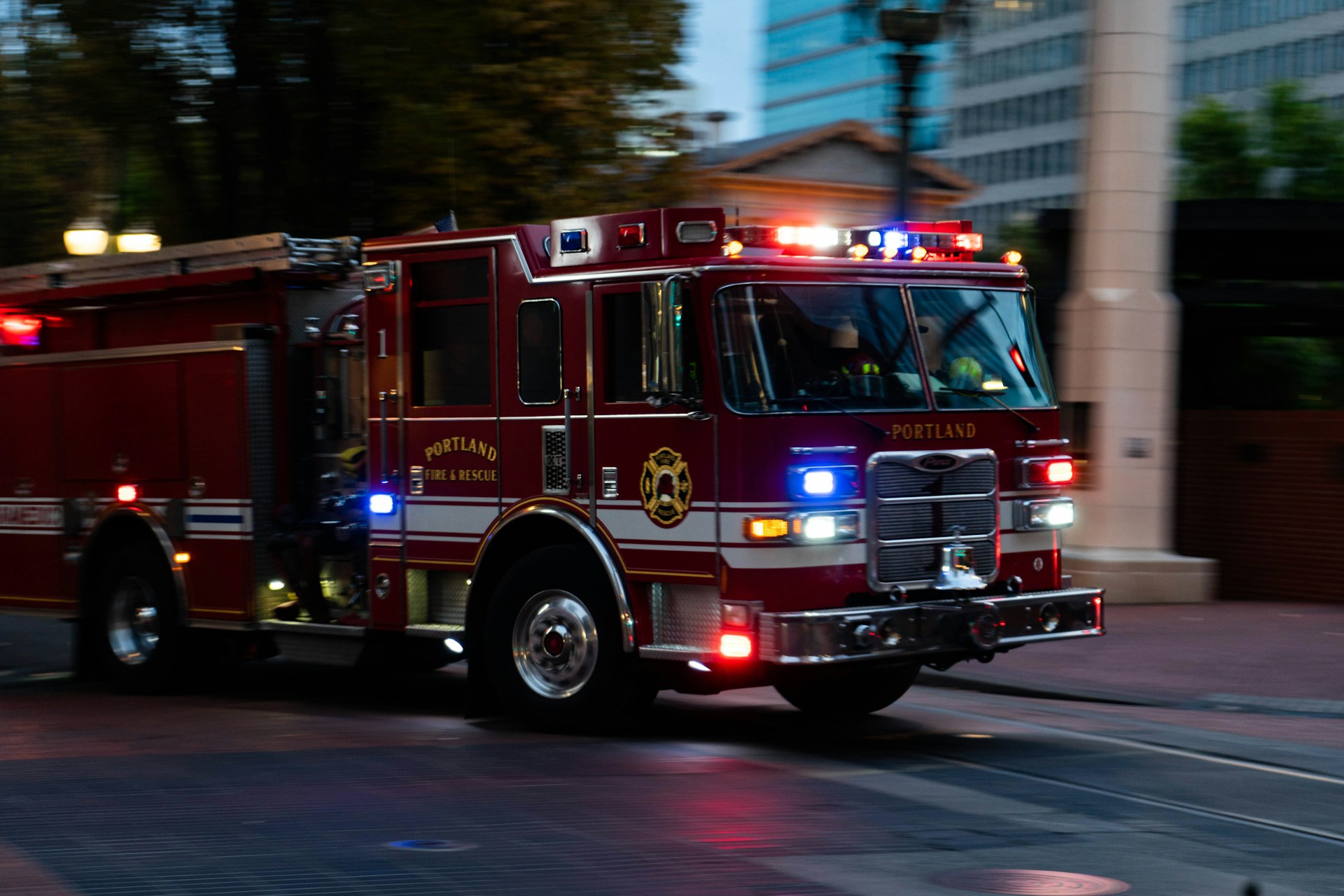 a fire truck driving down a street next to tall buildings