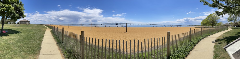 a sandy beach with a bridge in the distance