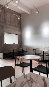 a room filled with tables and chairs next to a wall