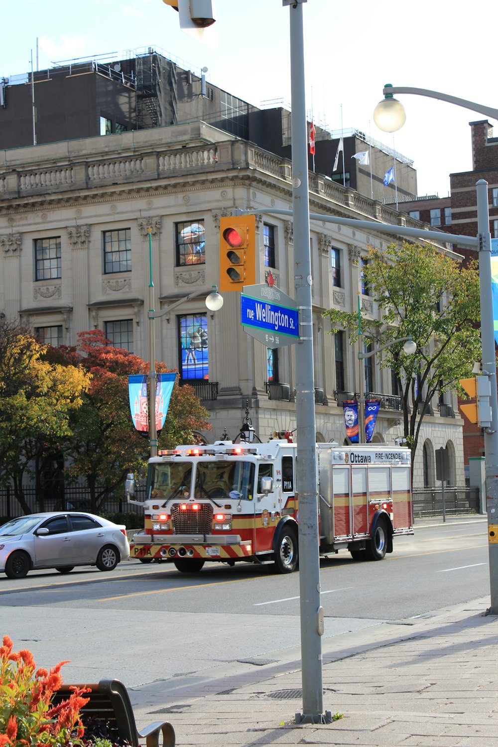 a fire truck driving down a street next to a tall building