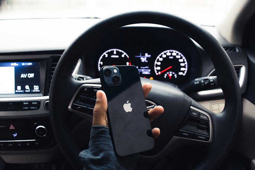 a person holding a cell phone in a car