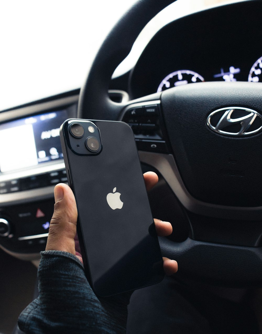a person holding an iphone in their car