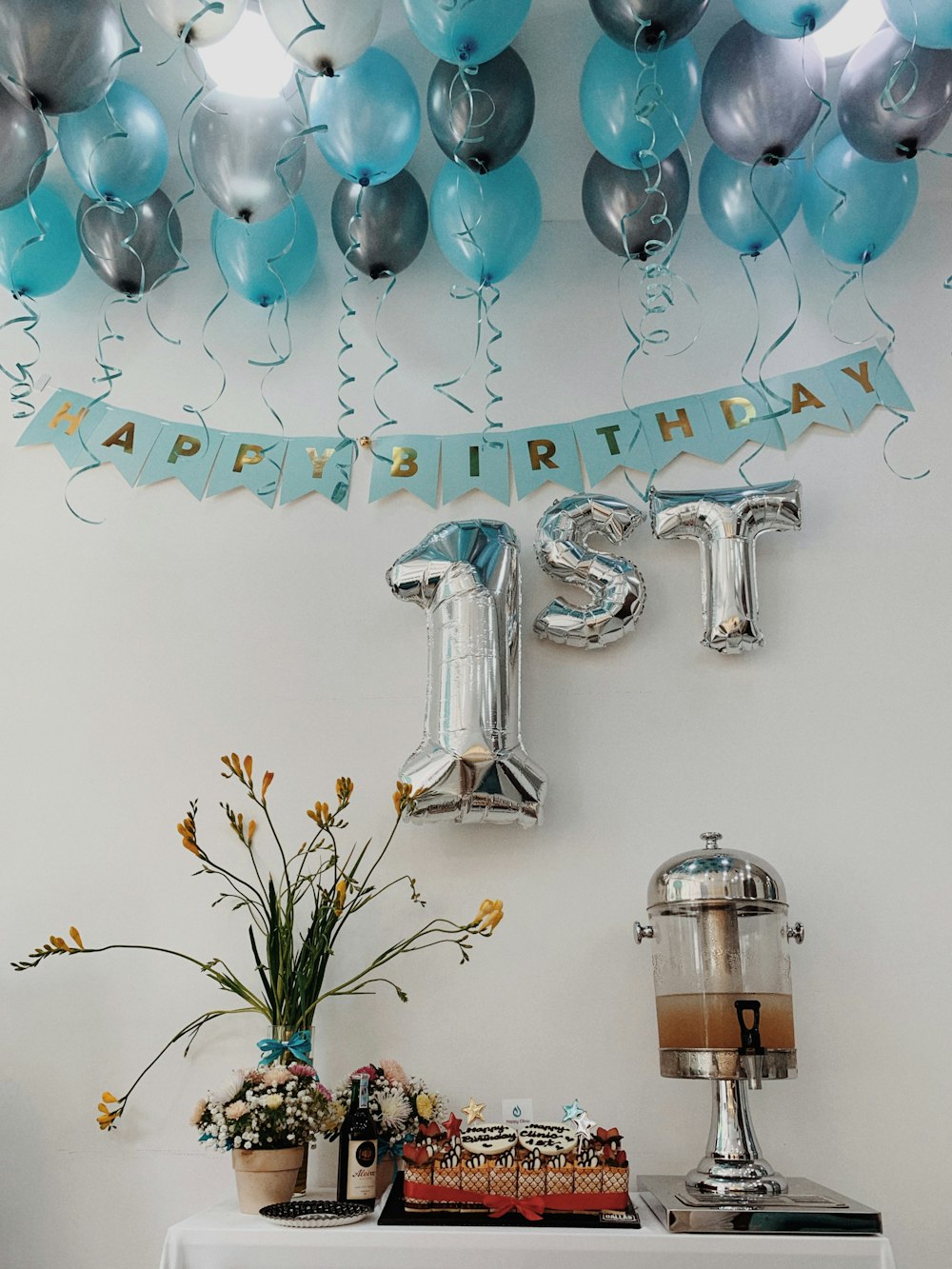 uma mesa coberta com balões e um bolo