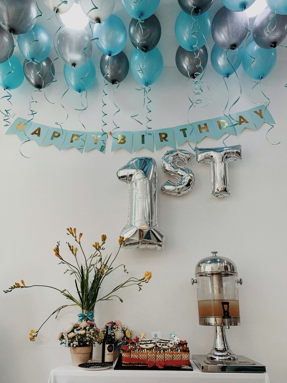 a table topped with balloons and a cake