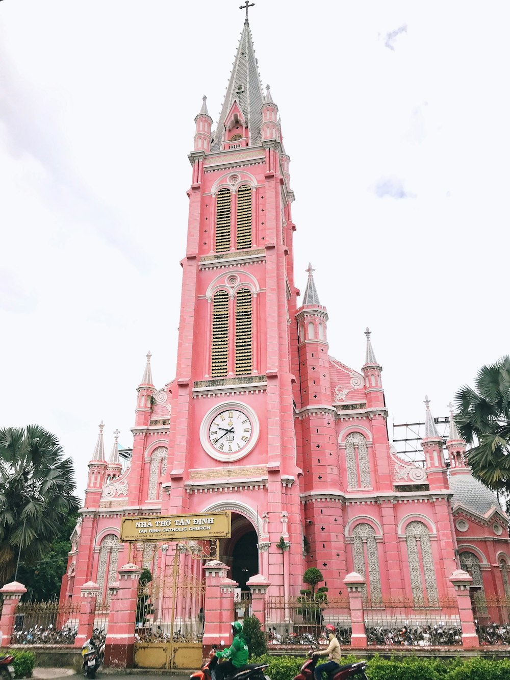 a large pink building with a clock on it's side