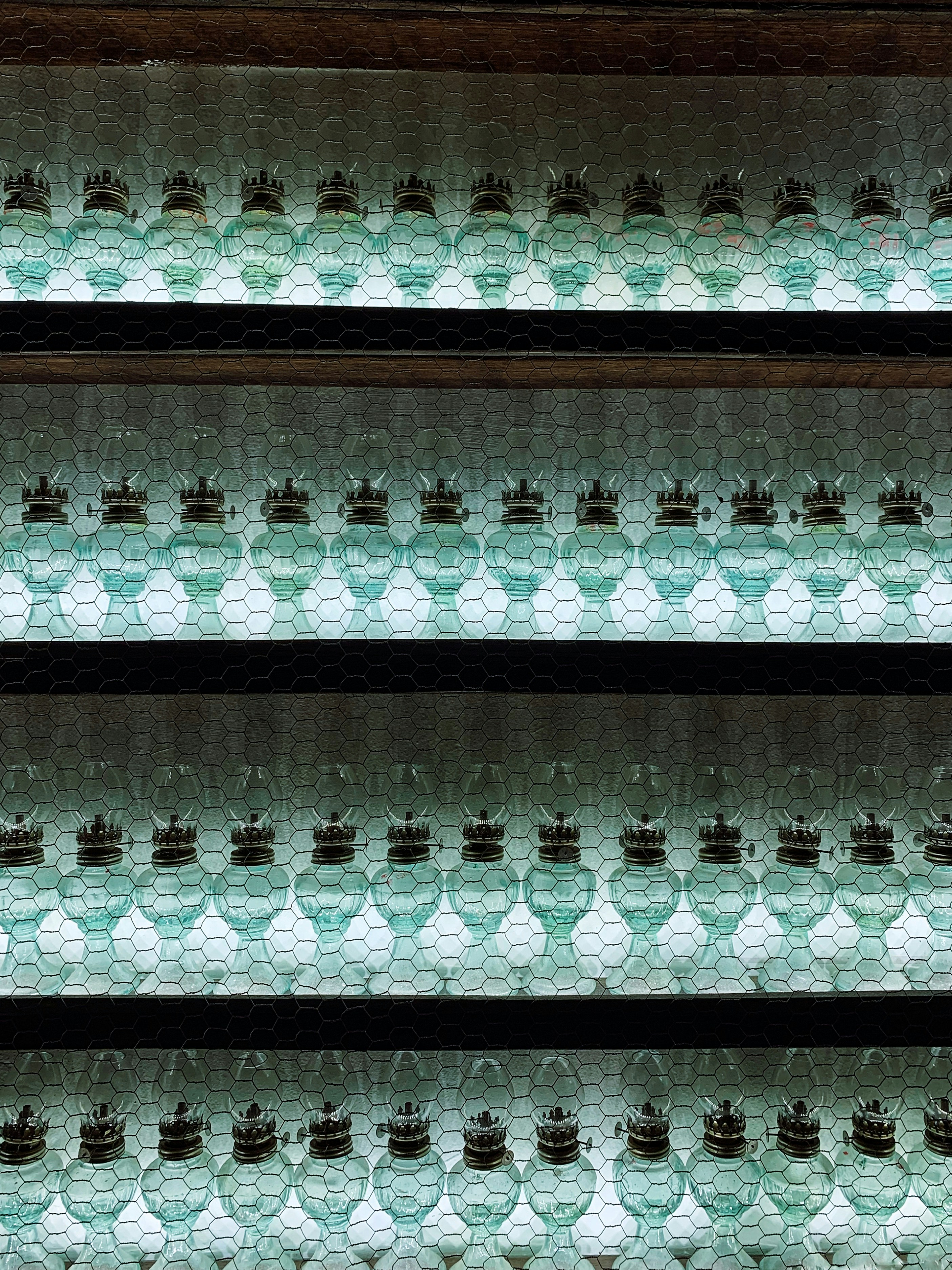 rows of glass bottles are lined up on a shelf