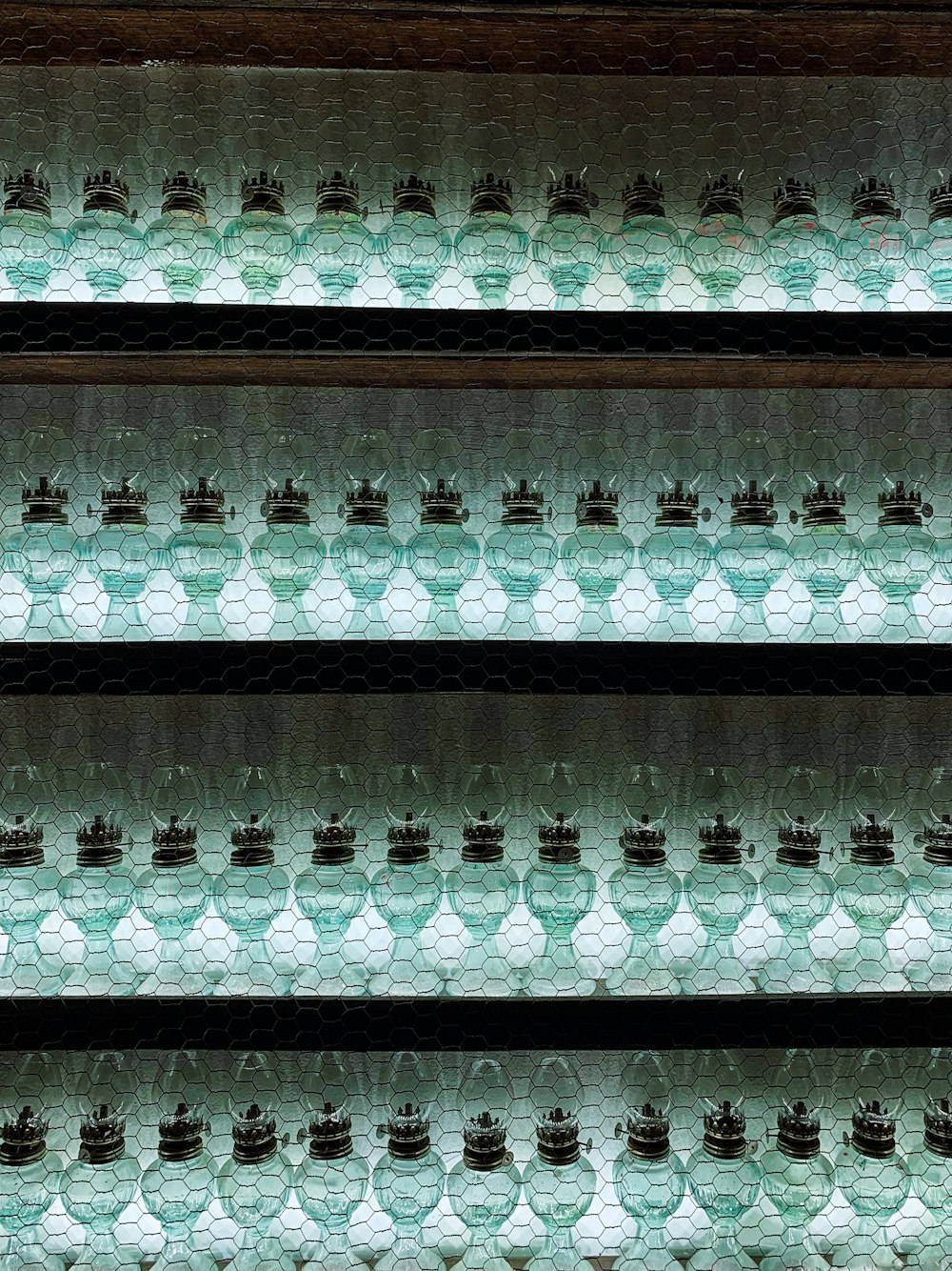 rows of glass bottles are lined up on a shelf