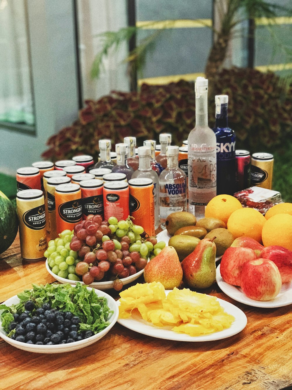 a wooden table topped with plates of fruit and drinks