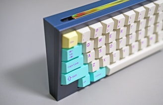 a white and blue computer keyboard with colorful keys