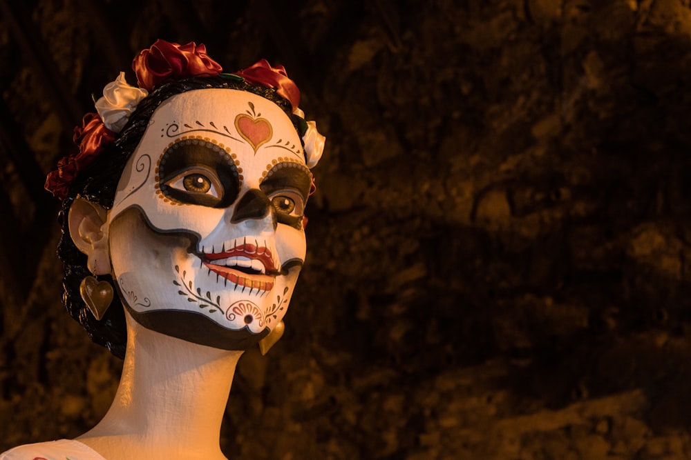 a woman with a painted face and a flower in her hair