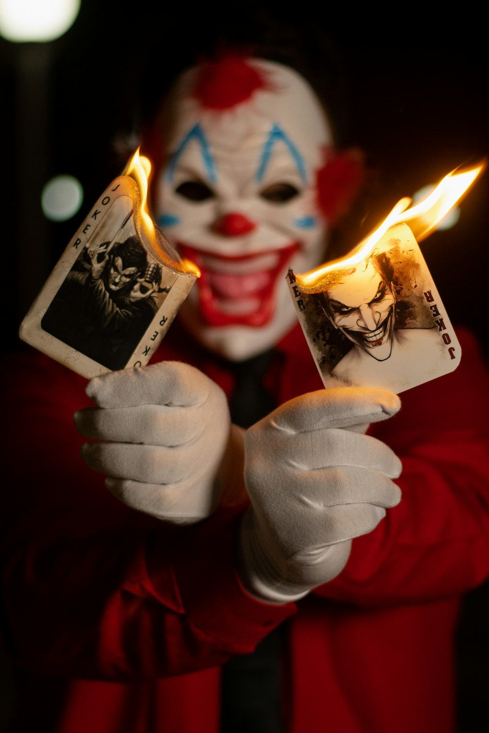 a person in a clown mask holding two cards