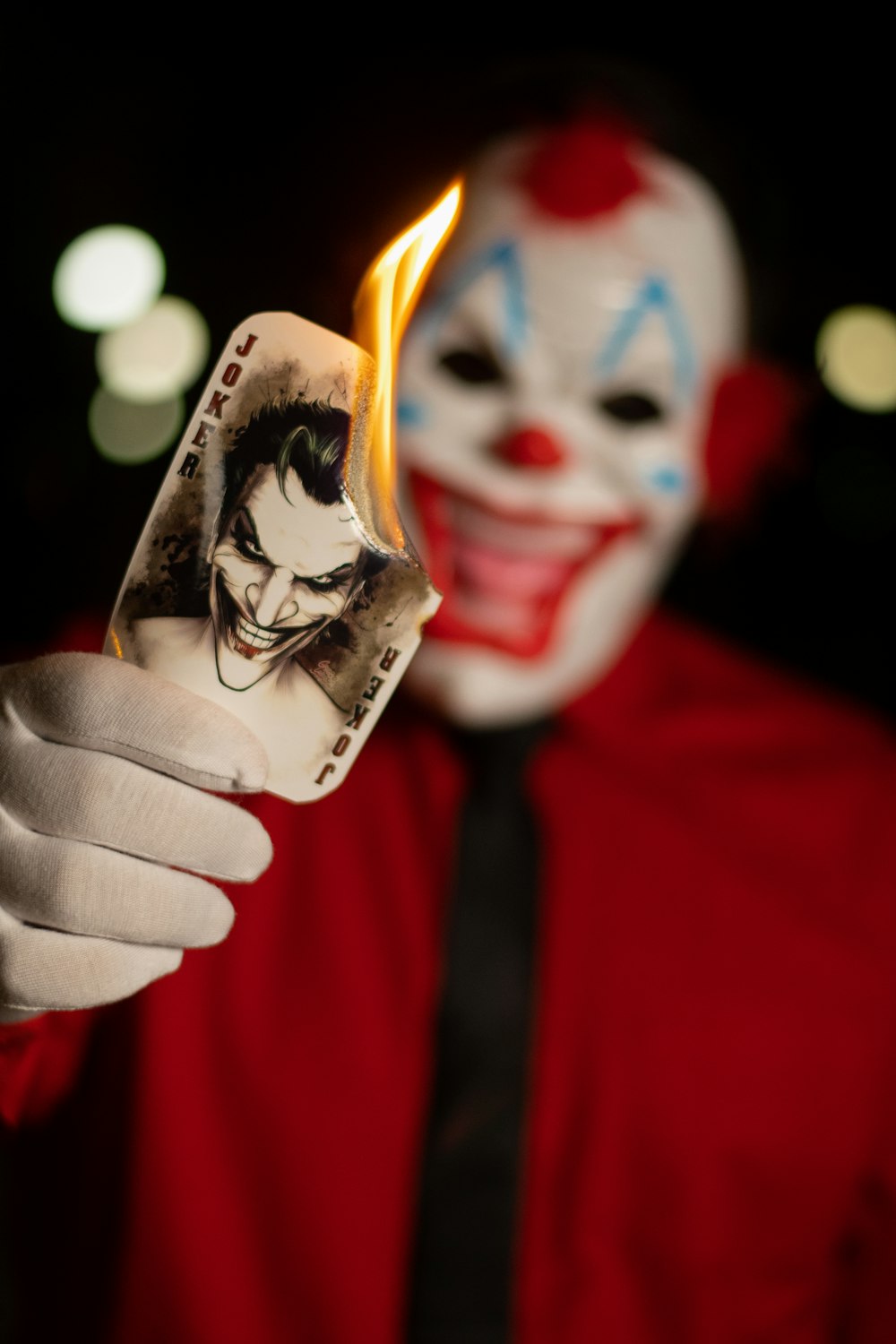 a man in a clown mask holding a cigarette lighter
