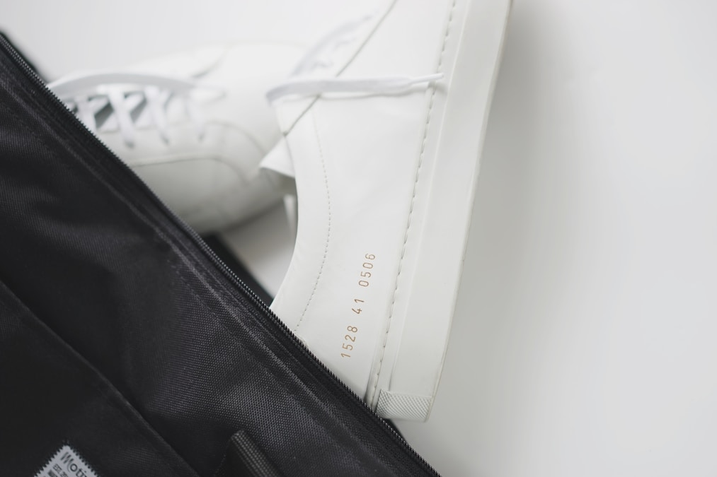 White training sneakers resting on top of a black gym bag
