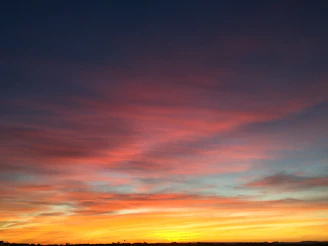 Sunset sky painted with hues of orange and purple, the sun’s energy fading gently.