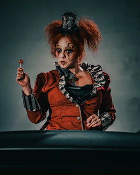 a woman dressed as a clown holding a flower