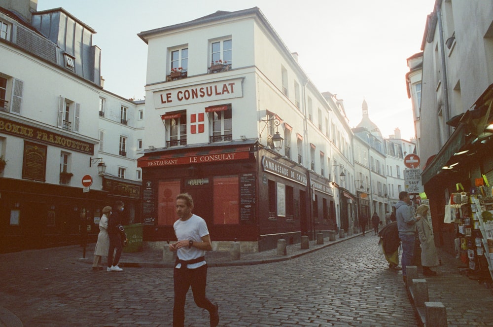 a man is running down a cobblestone street