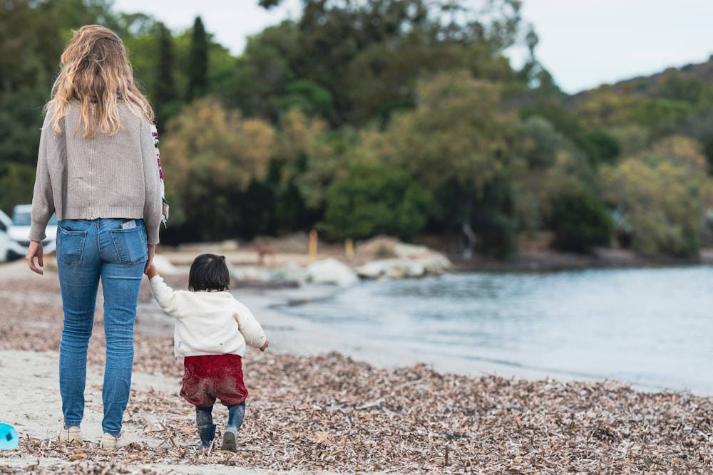 Una mujer y un niño caminando por una playa