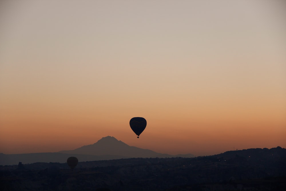 Ein Heißluftballon, der bei Sonnenuntergang am Himmel fliegt