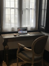 a laptop computer sitting on top of a wooden desk