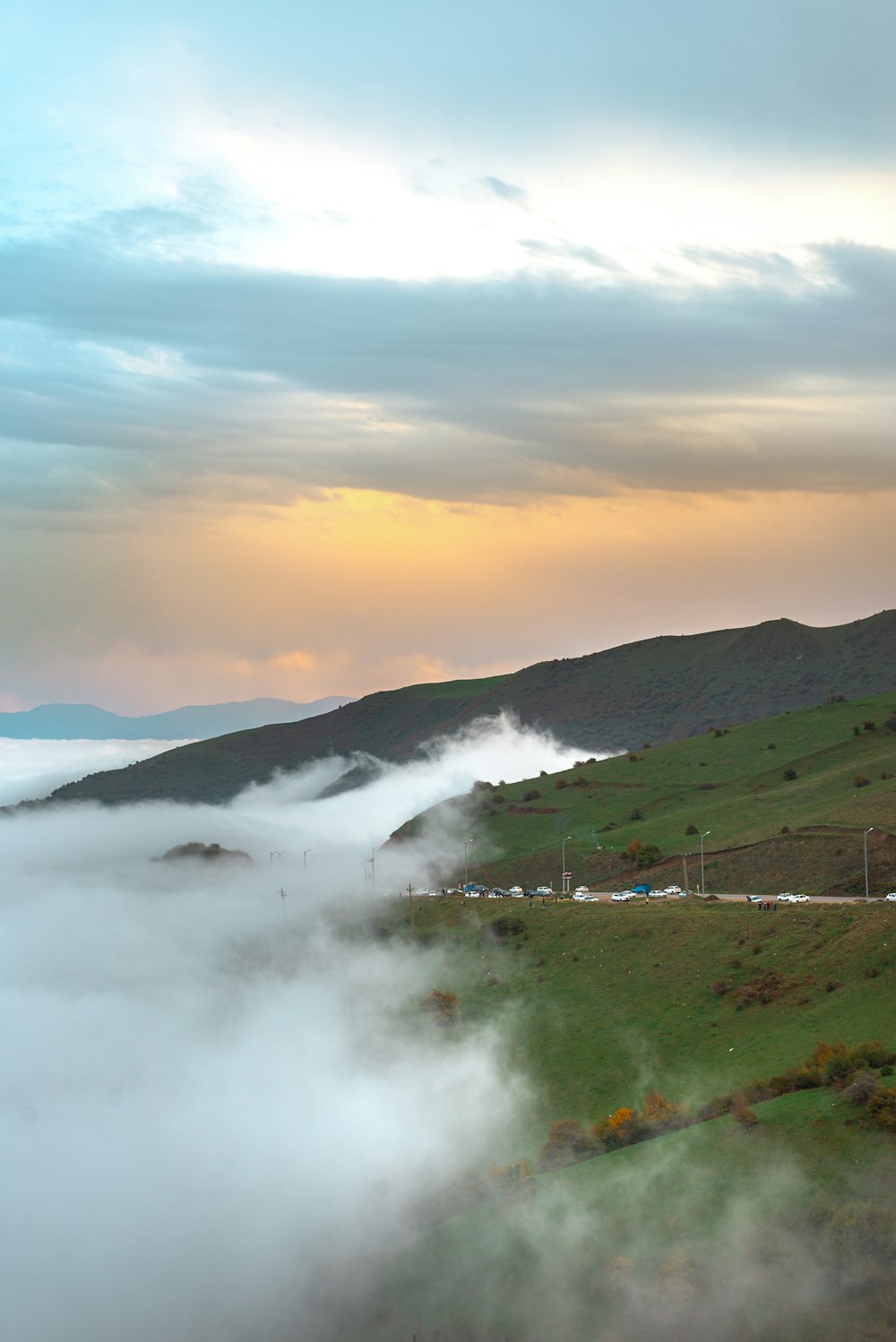 a foggy valley with a road in the foreground