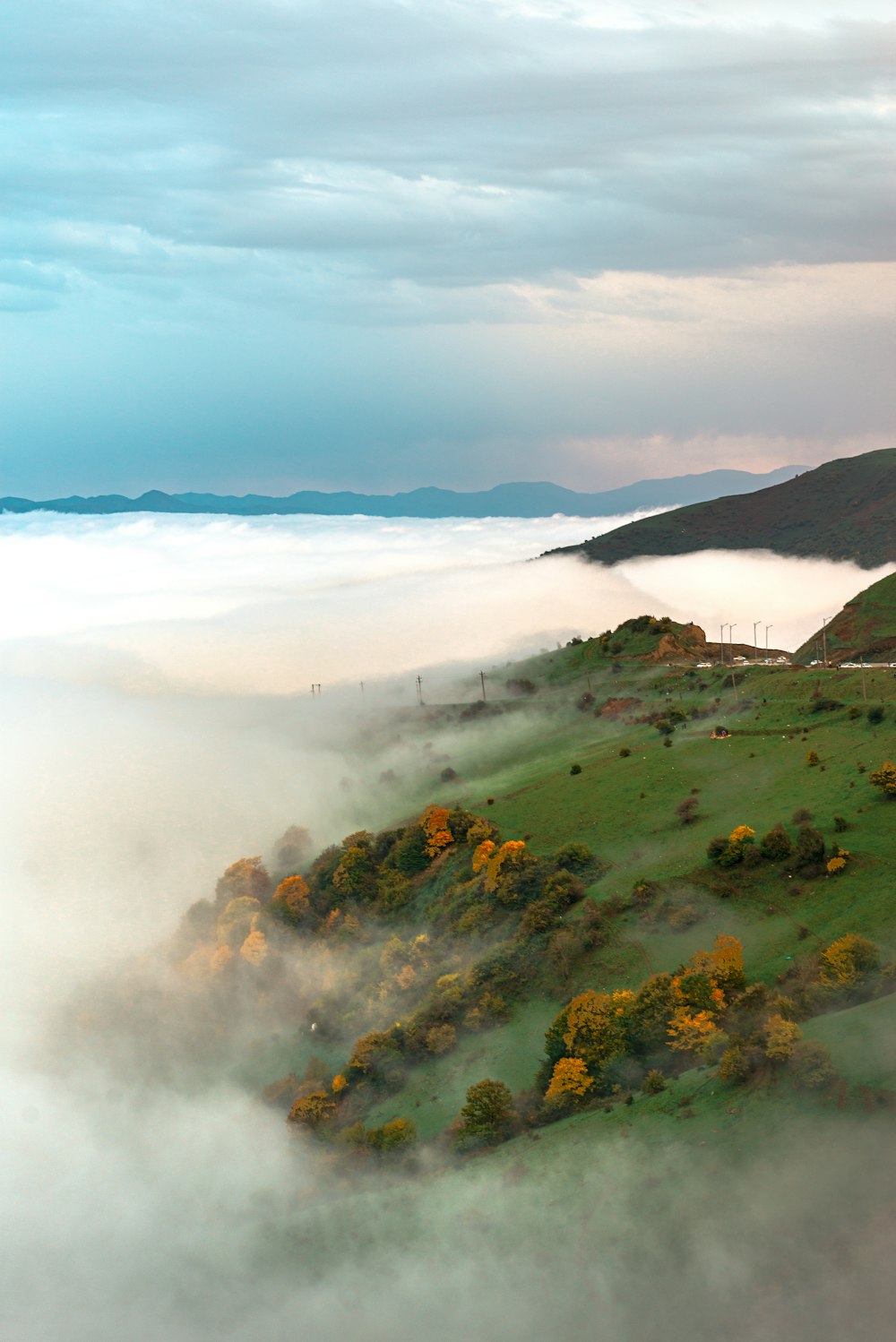 a hill covered in clouds and trees