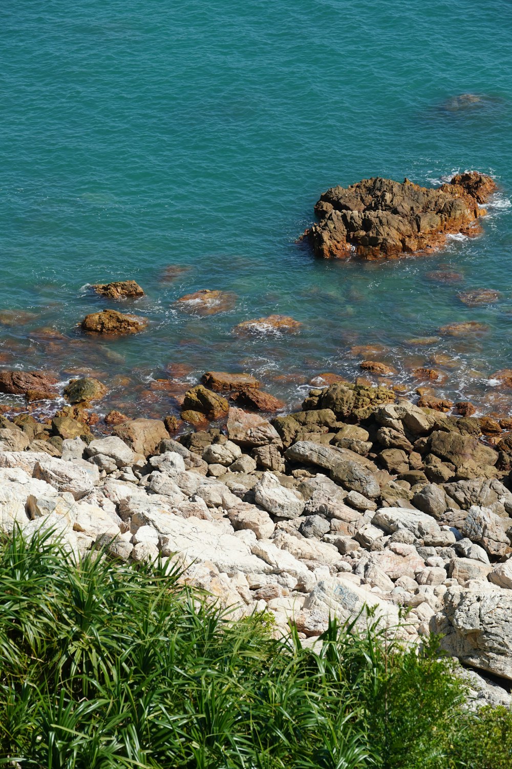 a view of a rocky beach with a body of water in the background