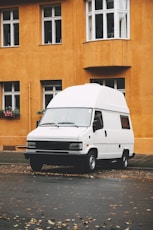 a white van parked in front of a yellow building