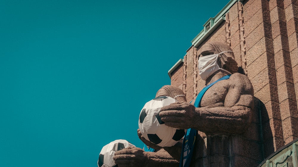 a statue of a man holding a soccer ball